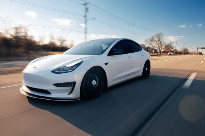 white-tesla-driving-on-the-road
