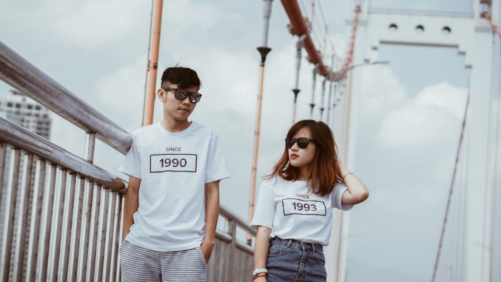 a guy and a girl in white t-shirts with a print of the year of birth